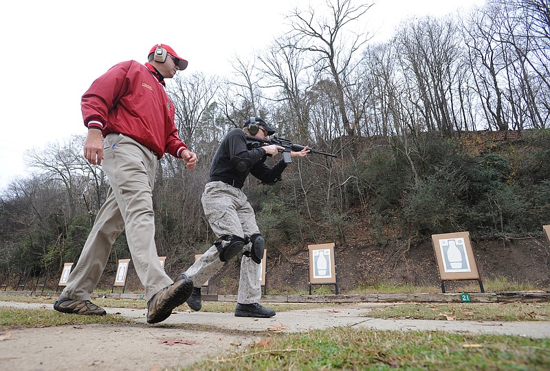 An instructor works with a law enforcement officer as he practices shooting targets at the Moccasin Bend firing range.