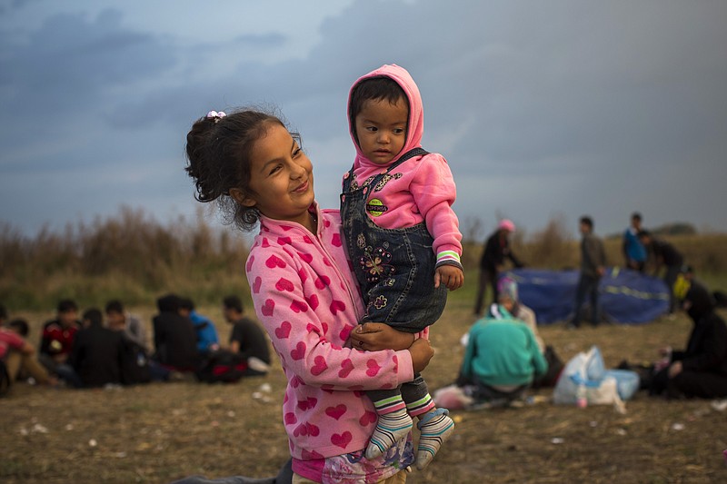 
              Afghan girls wait at a checkpoint near the Hungarian town of Roszke on Thursday, Sept. 3, 2015 after crossing the border illegally from Serbia with his family. The 28-nation European Union has been at odds for months on how to deal with the influx of more than 332,000 migrants this year as Greece, Italy and Hungary have pleaded for more help. (AP Photo/Santi Palacios)
            