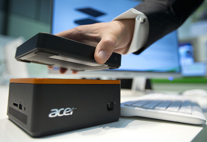 
              A staff member holds an external hard drive over a Revo Build modular PC at the stand of the electronic company Acer at the IFA 2015 tech fair  in Berlin, Germany, Wednesday, Sept. 2, 2015. (AP Photo/Michael Sohn
            