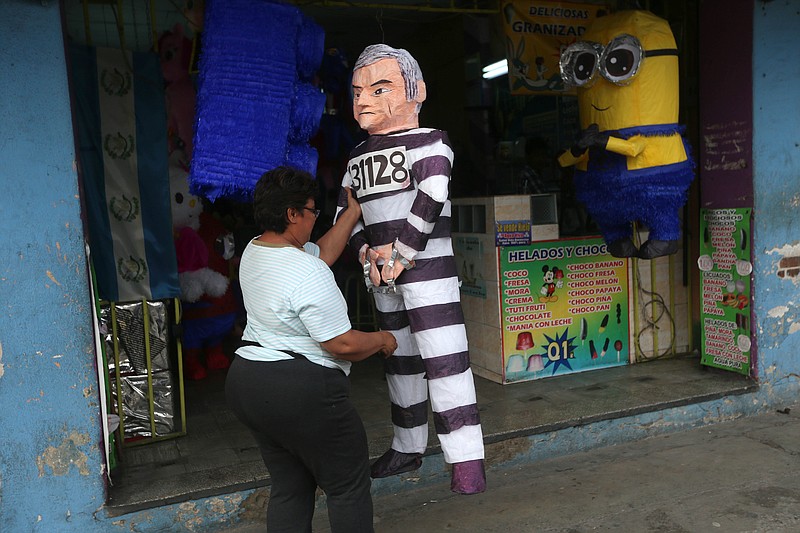 
              A pinata in the likeness of former Guatemalan president Otto Perez Molina dressed in prison garb is displayed for sale by Mirna Berducido in down town Guatemala City, Thursday, Sep. 3, 2015. Balducido who made the pinata 2 days ago expects to earn about $24 from the sale, as the former president is taken into custody on corruption charges. (AP Photo/Esteban Felix)
            