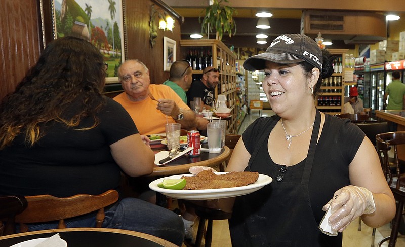
              In this photo taken Friday, June 12, 2015, Judith Castro serves a lunch order at a local grocery store in the Little Havana area of Miami. The Institute for Supply Management, a trade group of purchasing managers, issues its index of non-manufacturing activity for August 2015 on Thursday, Sept. 3, 2015. (AP Photo/Alan Diaz)
            