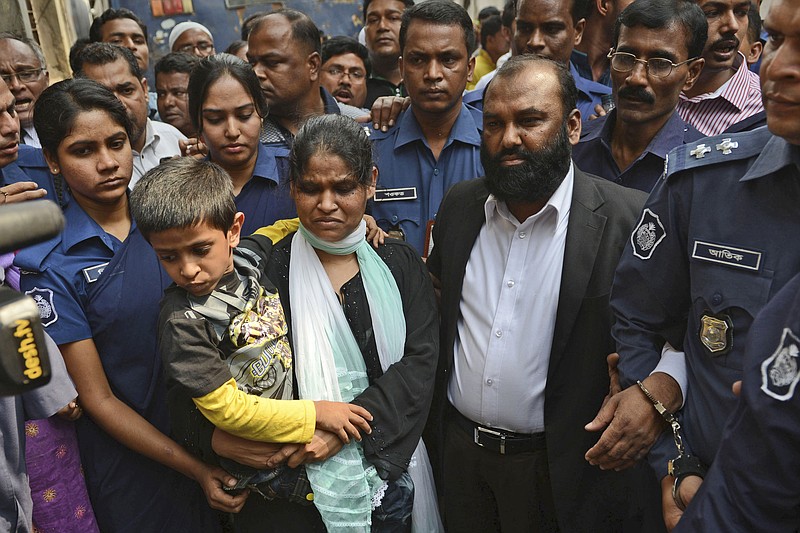 
              FILE- In this Feb. 9, 2014 file photo,two owners of Tazreen Fashions Ltd., Delwar Hossain, center right and his wife, Mahmuda Akter, center left are escorted by security personnel to a court in Dhaka, Bangladesh. A court in Bangladesh’s capital on Thursday, Sept. 3, 2015 indicted the two owners of the garment factory and 11 others facing homicide charges for a 2012 fire that killed 112 workers.  (AP Photo, file)
            