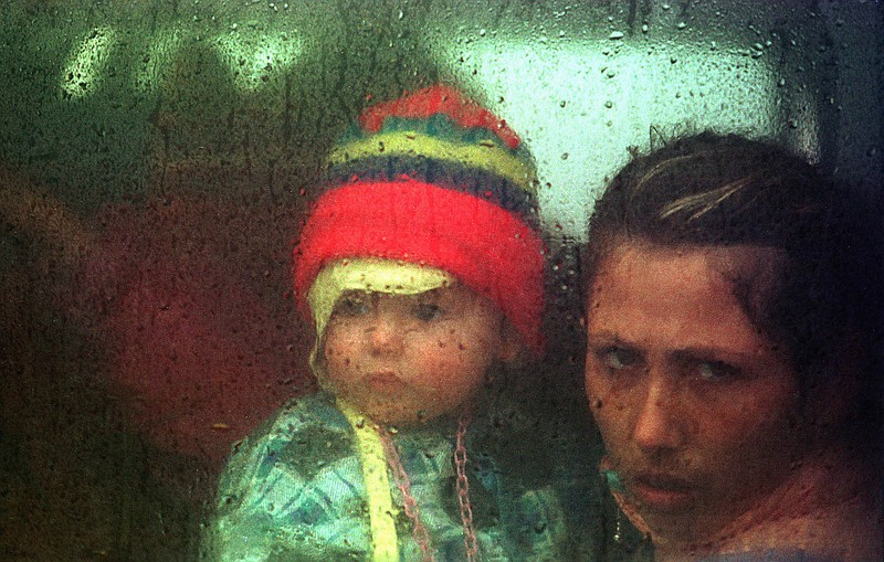 
              FILE - In this Friday, May 7, 1999 file photo, an ethnic Albanian mother and child bound for Canada leave for the airport from the Stenkovec refugee camp outside Skopje, Macedonia. They are among hundreds of thousands of refugees who fled Serbian forces in Kosovo in the previous month. Canada airlifted more than 5,000 people from Kosovo in the late 1990s. Canada has long prided itself for opening its doors wider than any nation to asylum seekers, but the number it welcomes has waned since the Conservative Prime Minister Stephen Harper took power almost 10 years ago. (AP Photo/John McConnico)
            