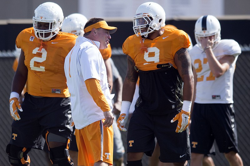In this Aug. 26, 2015, photo, Tennessee coach Butch Jones talks with players including Tennessee defensive end Derek Barnett (9) during practice in Knoxville, Tenn. Defensive lineman Shy Tuttle is at left. Derek Barnett aned Curt Maggitt make No. 25 Tennessee the only Football Bowl Subdivision program to return two players who posted double-digit sack totals last season. (Saul Young/Knoxville News Sentinel via AP)