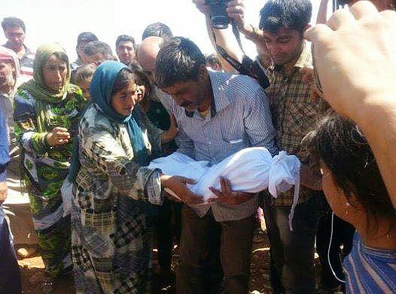 Relatives of 3-year-old Syrian Kurdish boy Aylan Kurdi carry his body, center, during his funeral procession with his mother Rehan, and his older brother Galib, in Kobani, Syria, on Friday. Aylan's body was discovered on a Turkish beach in sneakers, blue shorts and a red shirt on Wednesday after the small rubber boat he and his family were in capsized. They were among 12 migrants who drowned off the Turkish coast of Bodrum that day.