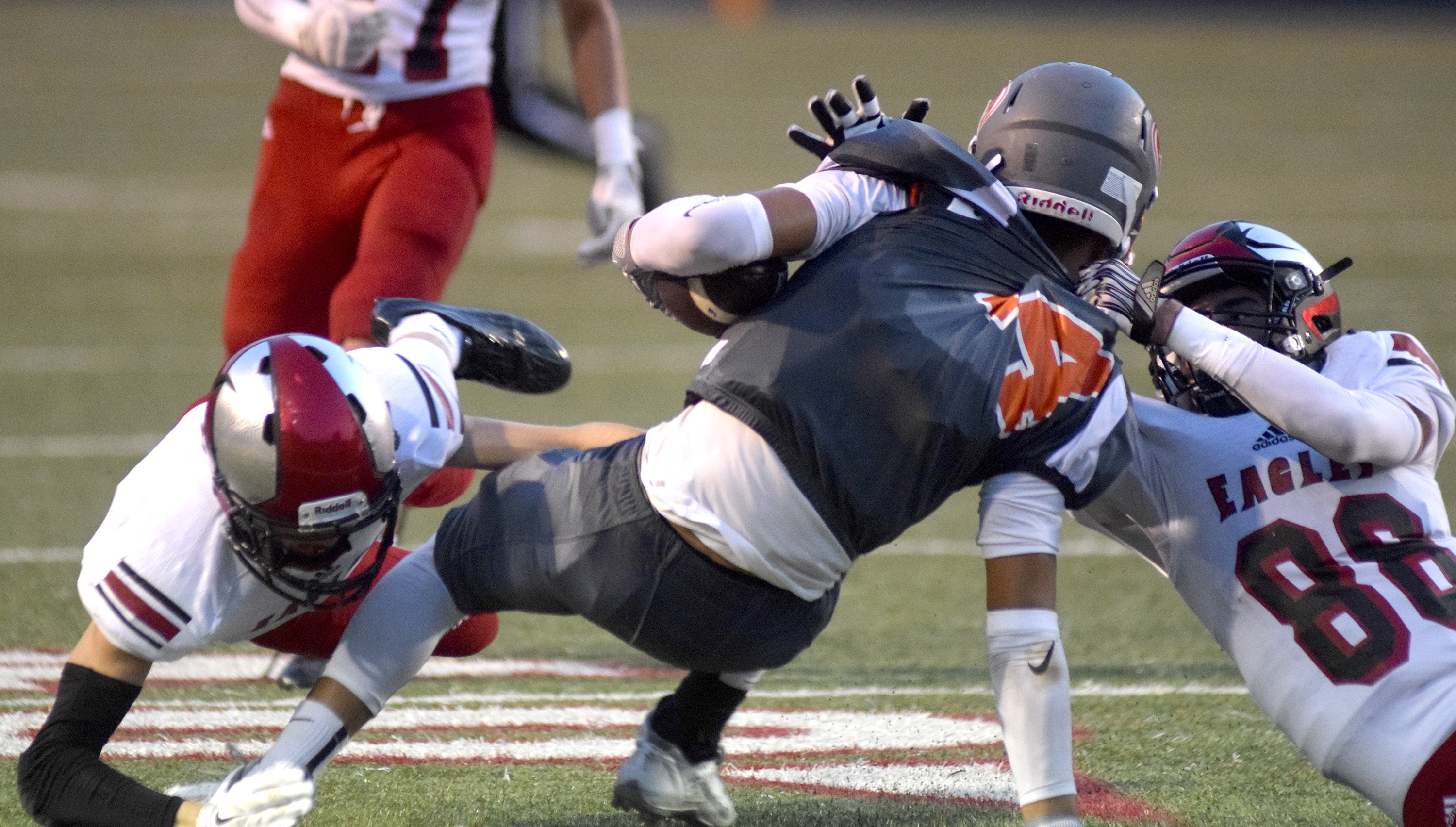 East Ridge's Dquantis Jones (14) is taken down by Signal Mountain's Jacob Wood (33) and Leyton Teal (88).   The East Ridge Pioneers hosted the Signal Mountain Eagles at Baylor School in TSSAA football action on Friday September 4, 2015.