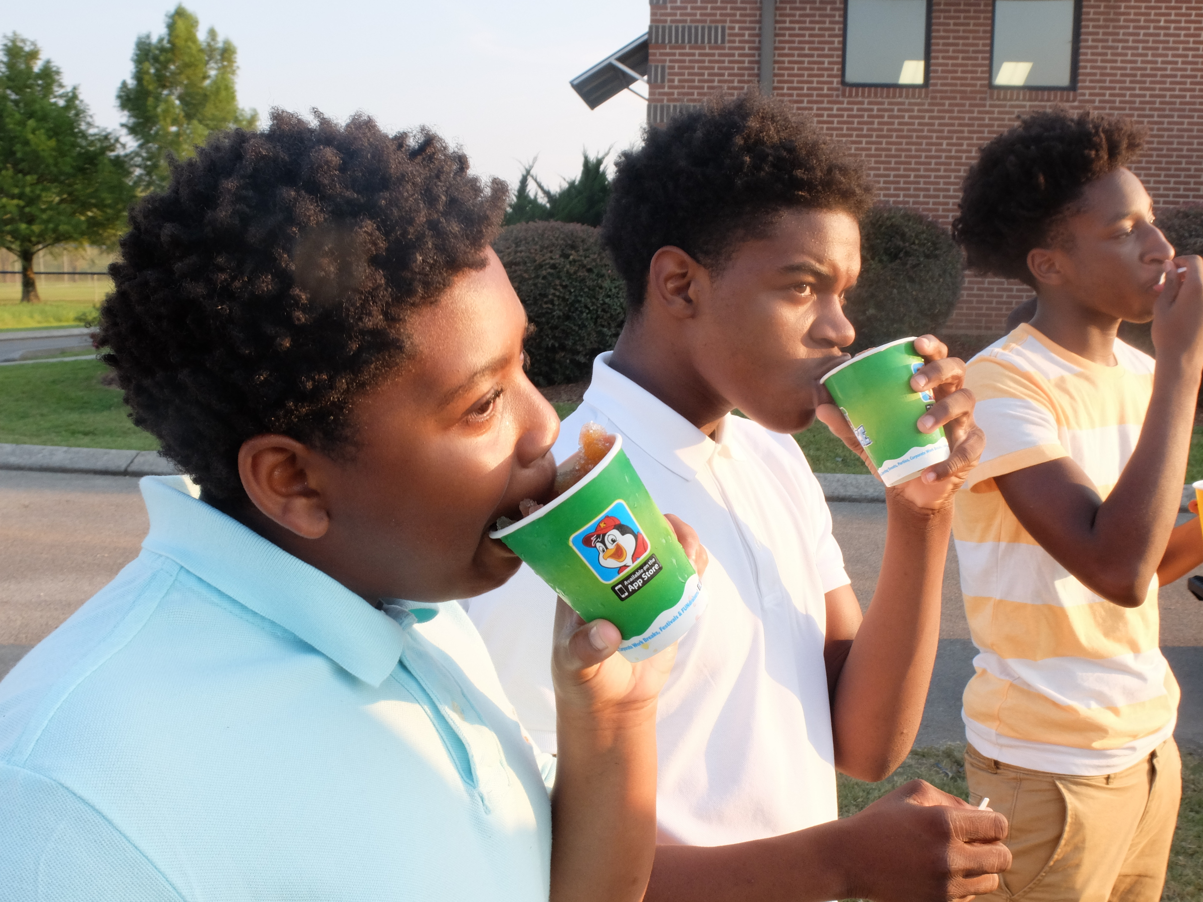 Brainerd fans Jamaal Ward, left, Jailen Moore and Demba Sow enjoy cups of Kona Ice before game time at Boyd-Buchanan Friday night.