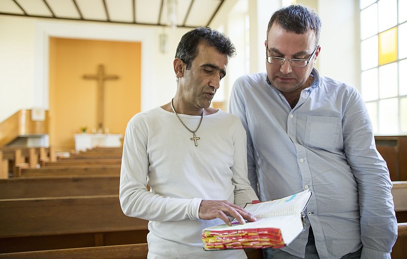
              Iranian asylum-seekers Aref Movasaq Rodsari, left, and Vesam Heydari stand in the Trinity Church in Berlin, Germany, Aug. 13, 2015. Hundreds of mostly Iranian and Afghan asylum seekers who have converted to Christianity at the evangelical Trinity Church in the leafy Berlin neighborhood. Most say true belief prompted their embrace of Christianity, but there’s no overlooking the fact that the decision will also greatly boost their chances of winning asylum by allowing them to claim they would face persecution if sent home. (AP Photo/Gero Breloer)
            