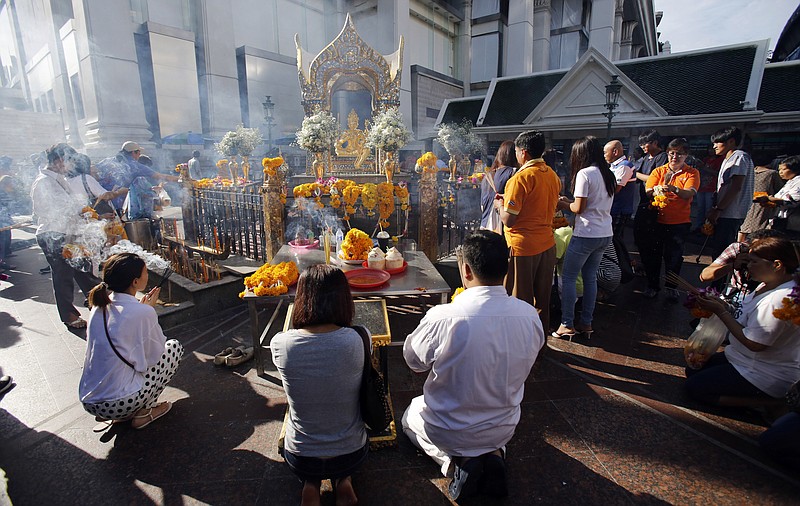 
              Visitors pray at Phra Phrom, the Thai interpretation of the Hindu god Brahma, at the Erawan Shrine in Bangkok, Thailand, Friday, Sept. 4, 2015. Thai authorities unveiled the restored centerpiece Friday of the Erawan Shrine, in the latest bid to restore confidence among Bangkok's tourism and business communities almost three weeks after a deadly bombing. (AP Photo/Sakchai Lalit)
            