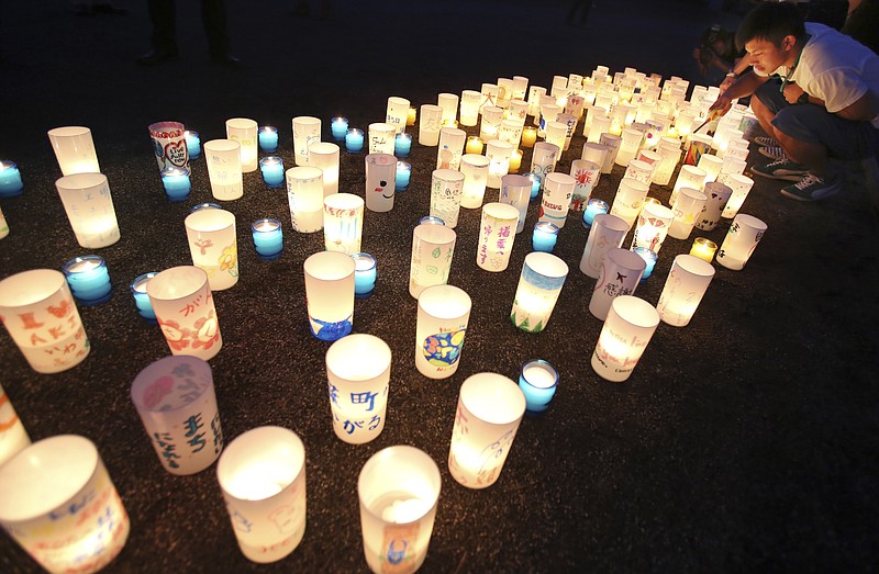 
              A man lights candles during a candle light installation event in Naraha, Fukushima, northern Japan, Friday, Sept. 4, 2015. Residents of Naraha will returns from Saturday to live in the town near the Fukushima nuclear power plant for the first time since the 2011 disaster. (AP Photo/Koji Sasahara)
            