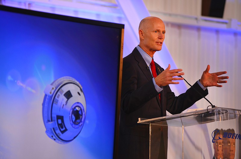 
              Gov. Rick Scott speaks during the grand opening for Boeing's Commercial Crew and Cargo Processing Facility (C3PF) at Kennedy Space Center, Fla. on Friday, Sept. 4, 2015. On the screen at left is a rendering of the CST-100 Starliner. The building was formerly a processing facility for the space shuttle. (Malcolm Denenark/Florida Today via AP)
            