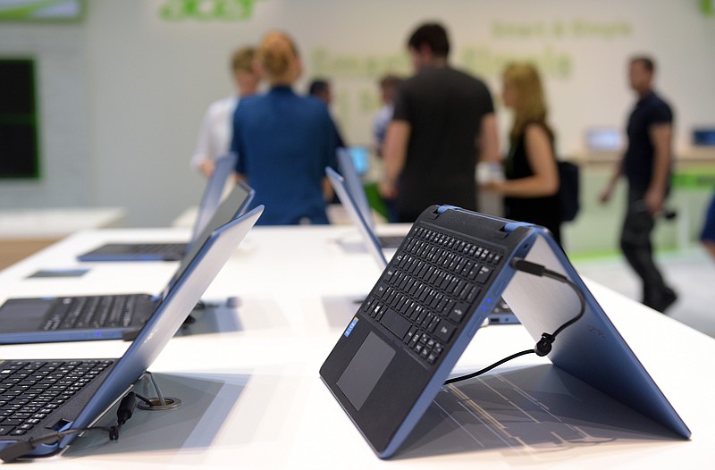 
              In this Sept. 2, 2015 photo visitors look at Acer laptops that run Windows 10 at the Acer company booth, during the first press day for the International Consumer Electronics Fair 'IFA', at the exhibition grounds in Berlin. (Rainer Jensen/dpa via AP)
            