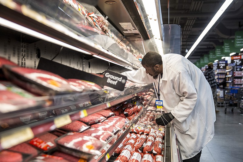 Walmart employee Duran Ware works in the meats section at a store in Washington earlier this year. Walmart, the largest private employer in the country, announced that it would increase wages for a half-million employees, but recently reduced hours of some of those employees to curtail costs.