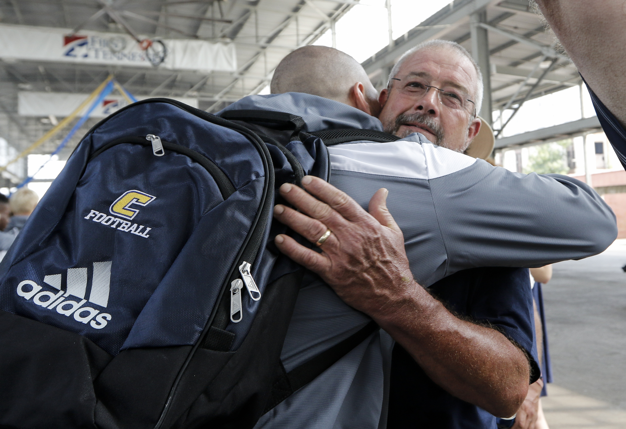 Charlie Dye, right, hugs his son, tight-end Chad Dye, as the UTC football team enters the First Tennessee Pavilion before the Mocs' season-opener football game against Jacksonville State at Finley Stadium on Saturday, Sept. 5, 2015, in Chattanooga, Tenn.