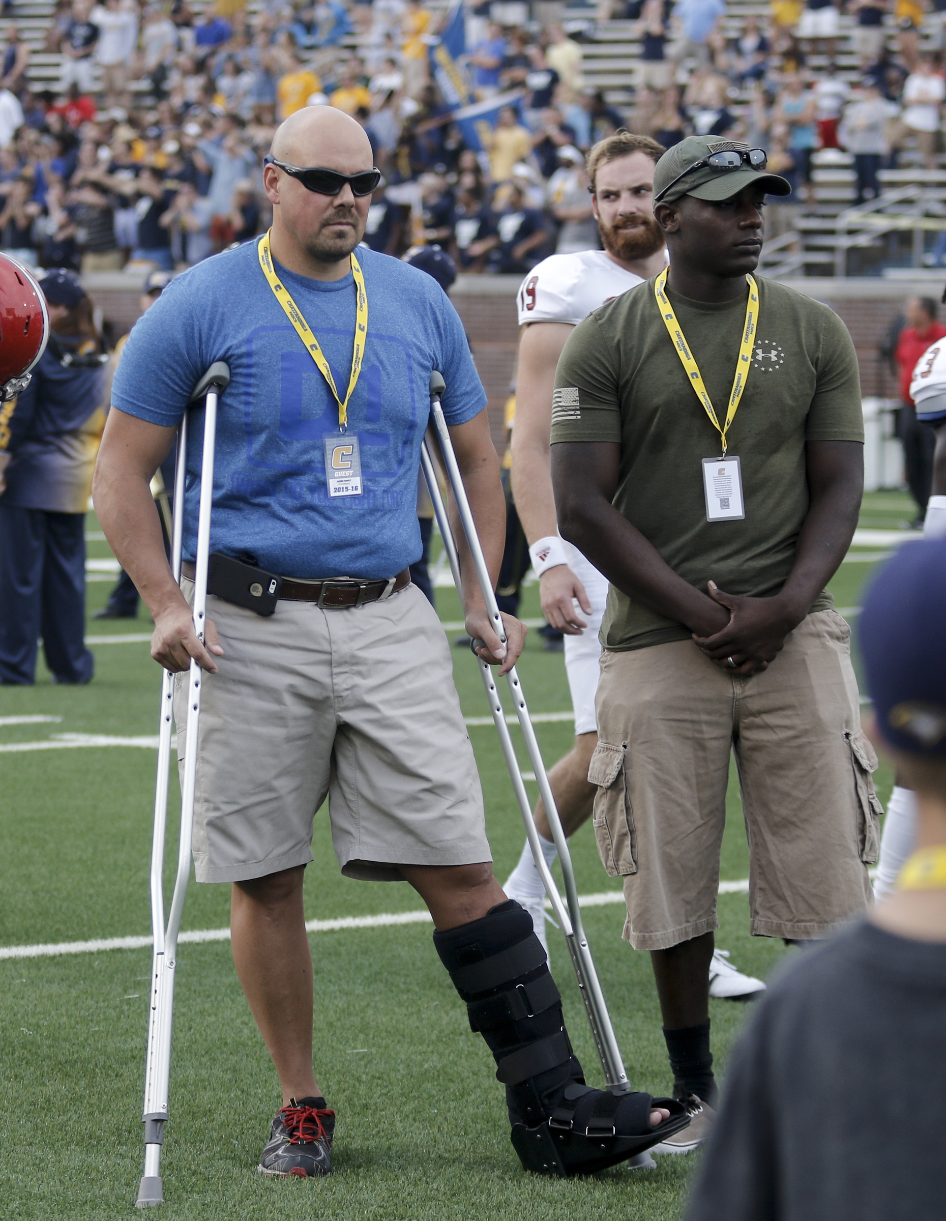 Chattanooga Police Officer Dennis Pedigo, left, and USMC Sgt. DeMonte Cheeley, who were both injured in the July 16 shootings, head to the coin toss before the Mocs' season-opener football game against Jacksonville State at Finley Stadium on Saturday, Sept. 5, 2015, in Chattanooga, Tenn.