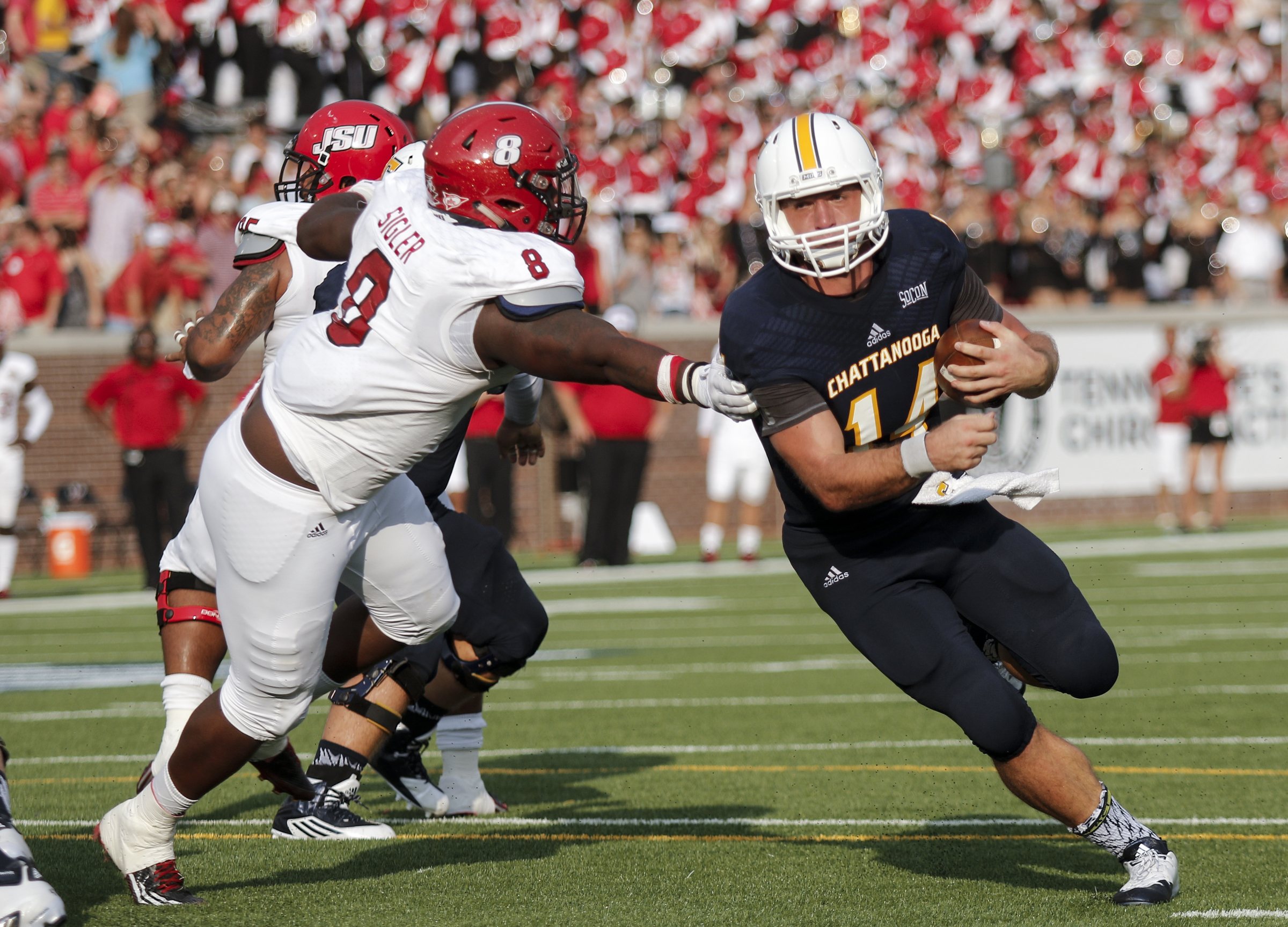 UTC quarterback Jacob Huesman rushes around Jacksonville State defensive lineman Devaunte Sigler during the Mocs' season-opener football game against Jacksonville State at Finley Stadium on Saturday, Sept. 5, 2015, in Chattanooga, Tenn.