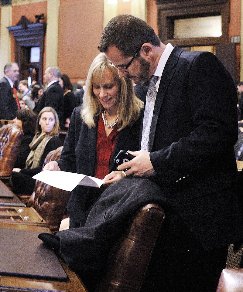 
              FILE- In this Jan. 14, 2015 photo, Rep. Cindy Gamrat, R-Plainwell, talks with Rep Todd Courser, R-Lapeer in the House of Representatives in Lansing. The Tea Party activists promised to shake up the political establishment when they were elected to the state Legislature, but have succeeded in a way they didn't imagine. Next week, the House will begin hearings on whether to expel the pair from office over a sex scandal that has overshadowed the session's top policy issues. (Dale G. Young /Detroit News via AP)  DETROIT FREE PRESS OUT; HUFFINGTON POST OUT; MANDATORY CREDIT
            