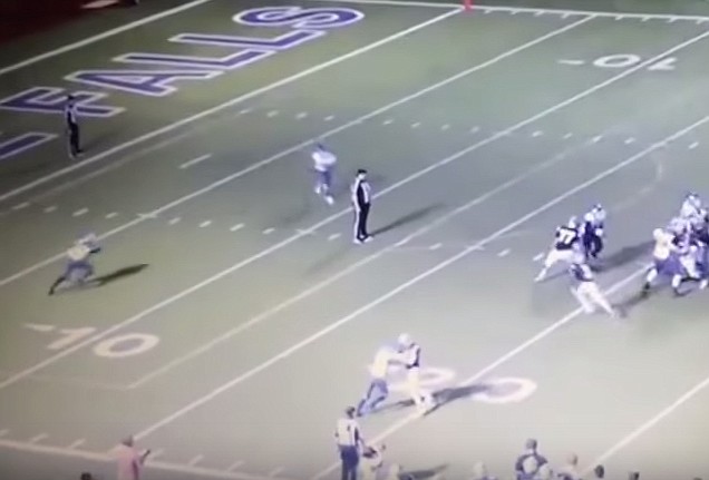 Two high school players close in to tackle a referee in the screenshot from this YouTube video.