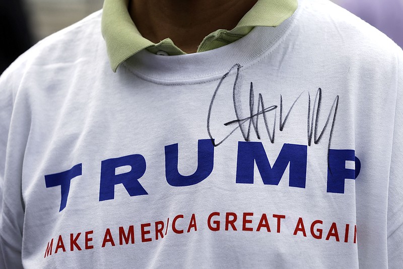 
              FILE - In this Aug. 29, 2015, file photo, Donald Trump supporter John Wang wears a shirt autographed by the Republican presidential candidate outside the National Federation of Republican Assemblies in Nashville, Tenn. It’s been a tumultuous political summer. The unexpected rises of billionaire Donald Trump and socialist Bernie Sanders. When it comes to Trump, Ohio Republicans have a palpable excitement about his brash brand of politics, and a deep uncertainty about his qualifications to serve as president.  (AP Photo/Mark Humphrey, File)
            
