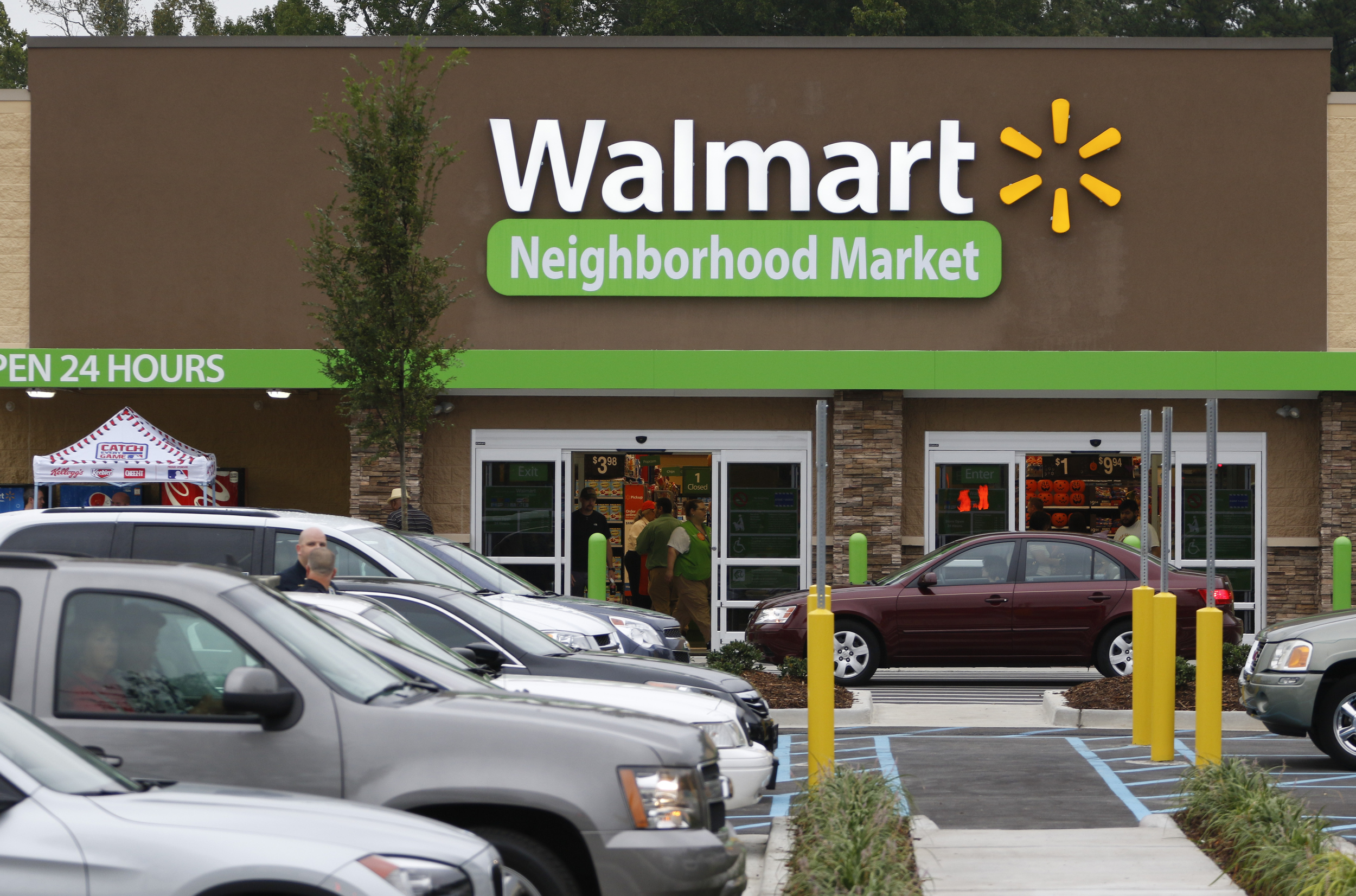 Patrons fill the parking lot and enter the new building during the grand opening of the Walmart Neighborhood Market off of East Brainerd Road in Chattanooga, Tenn., on September 9, 2015.