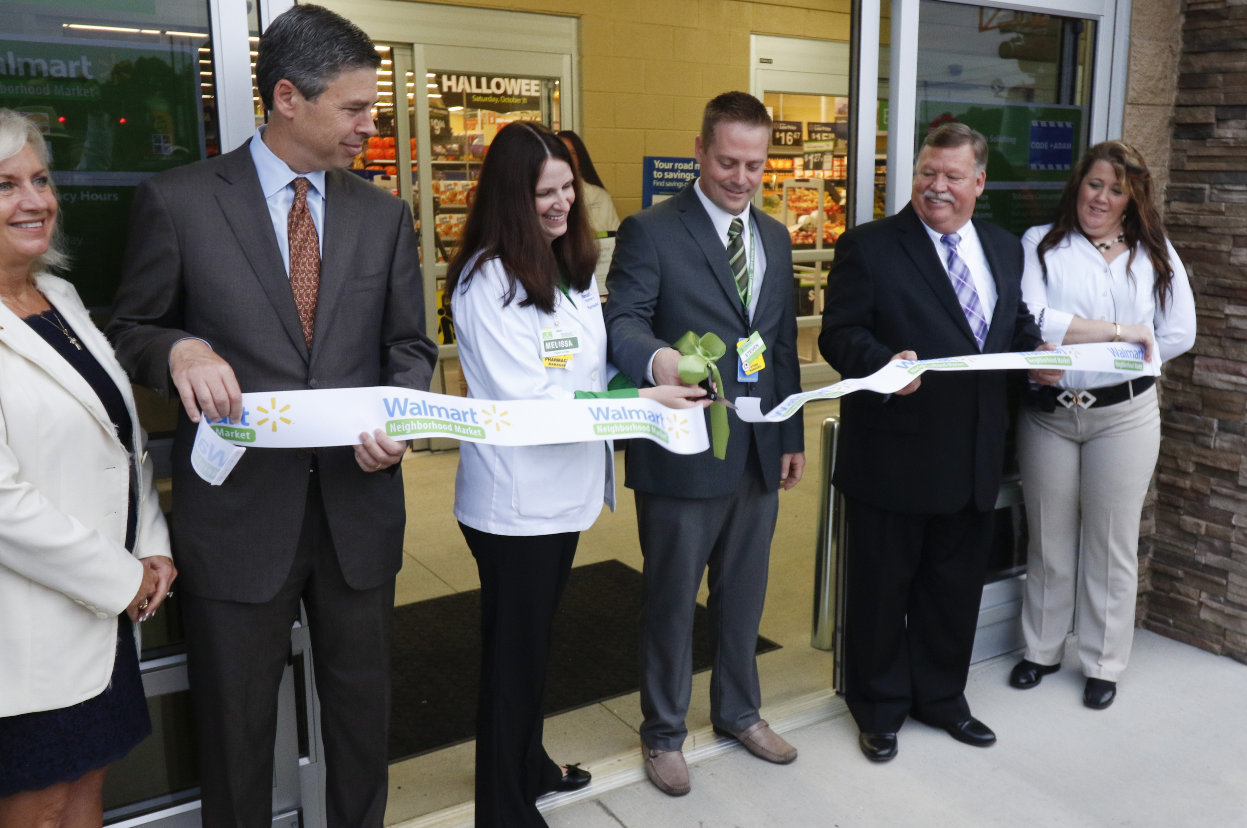 Officials perform a ribbon cutting during the grand opening of the Walmart Neighborhood Market off of East Brainerd Road in Chattanooga, Tenn., on September 9, 2015.