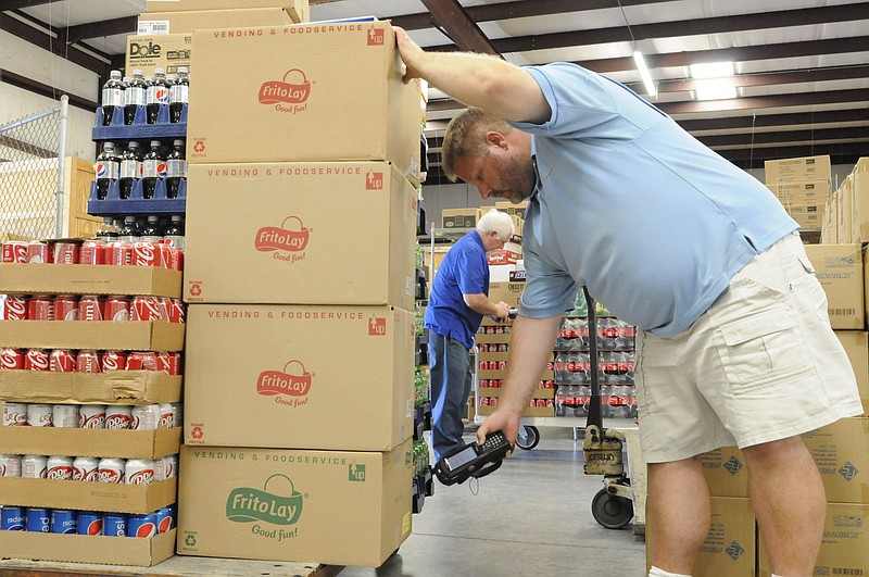Warehouse manager Chris Hight inventories product scheduled for delivery Wednesday as assistant Ralph Hibbs, background, goes about his duties inside the Five Star warehouse in Ringgold.
