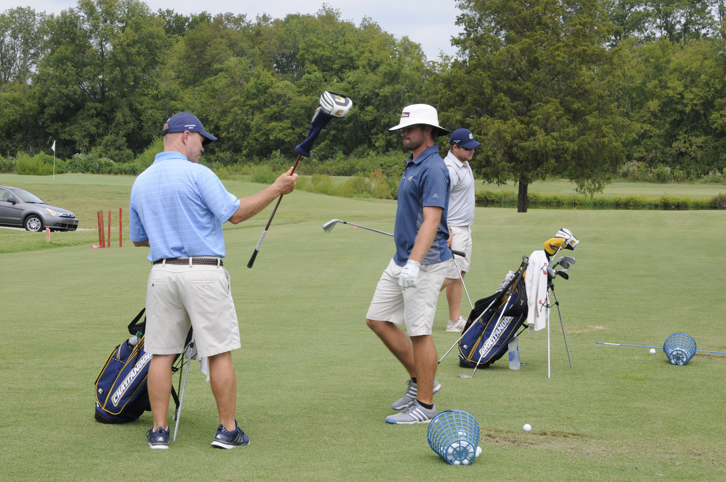 University of Tennessee at Chattanooga golf coach Mark Guhne holds a driver while talking to Brooks Thomas Wednesday during practice at the UTC Golf center on Hickory Valley Road.