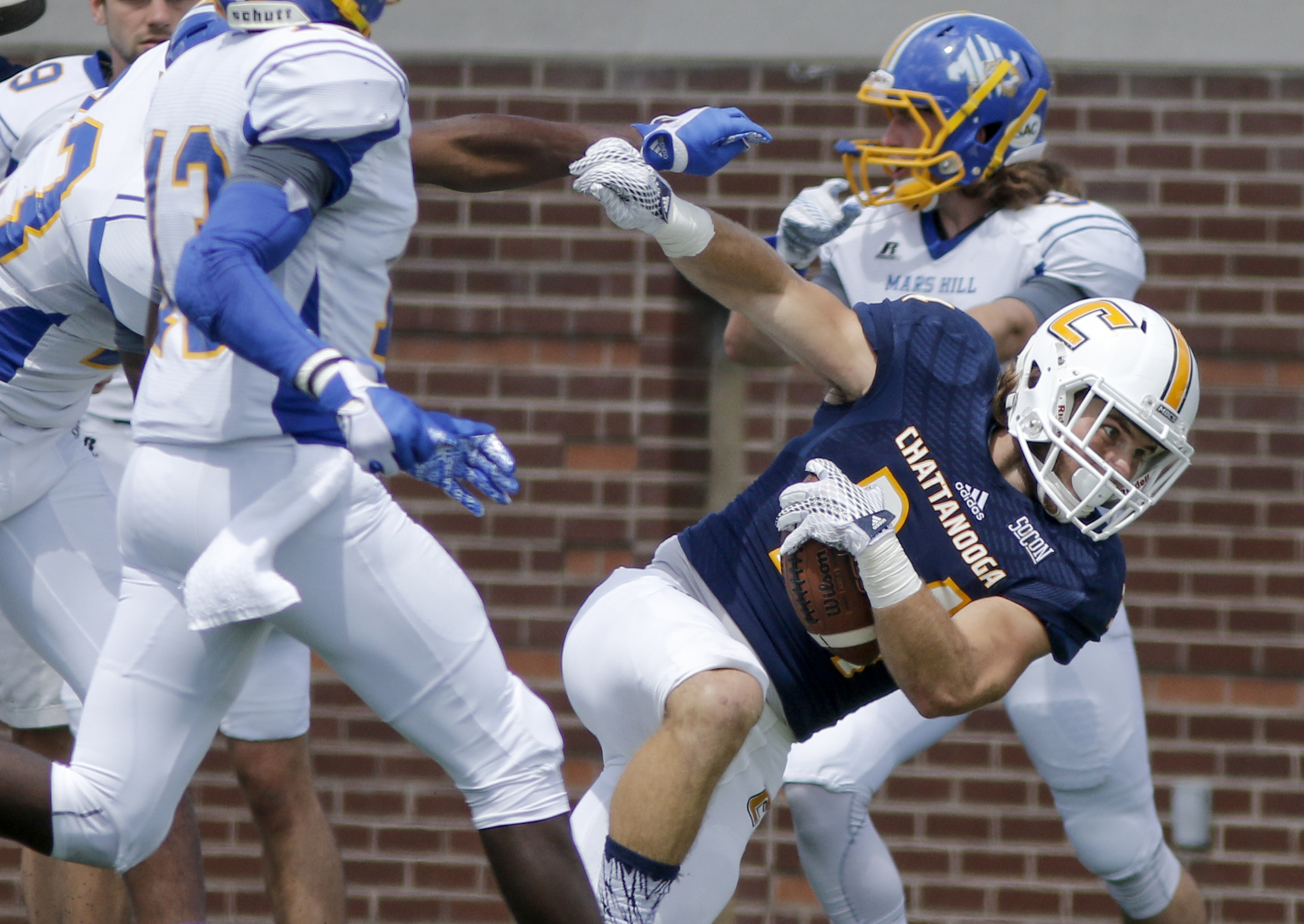 UTC running back Derrick Craine is forced out of bounds by Mars Hill defenders during the Mocs' football game against the Lions at Finley Stadium on Saturday, Sept. 12, 2015, in Chattanooga, Tenn. UTC won 44-34.