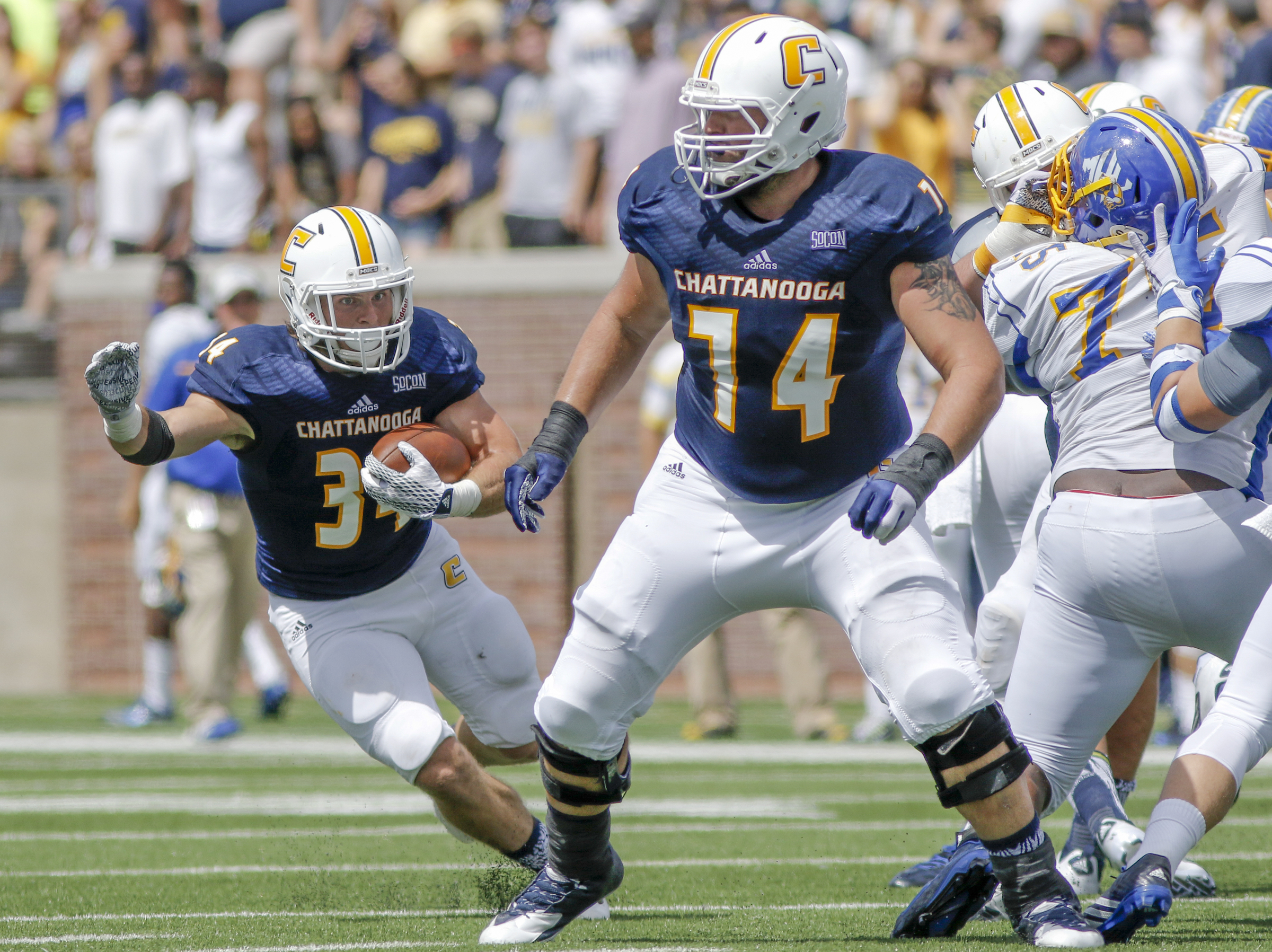 UTC running back Derrick Craine, left, breaks around teammate Synjen Herren during the Mocs' football game against the Mars Hill Lions at Finley Stadium on Saturday, Sept. 12, 2015, in Chattanooga, Tenn. UTC won 44-34.