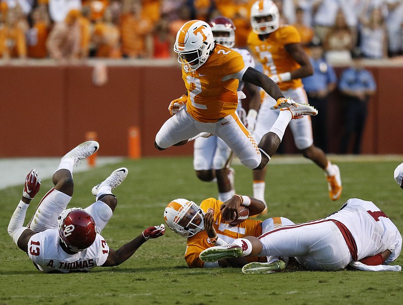UT's Pig Howard (2) launches himself over his quarterback Joshua Dobbs (11) after Oklahoma's Ahmad Thomas (13) and Dominique Alexander (1) took Dobbs down during the first half of play Saturday. The Volunteers played the Sooner's at home on September 12, 2015 at Neyland Stadium in Knoxville, Tennessee. 