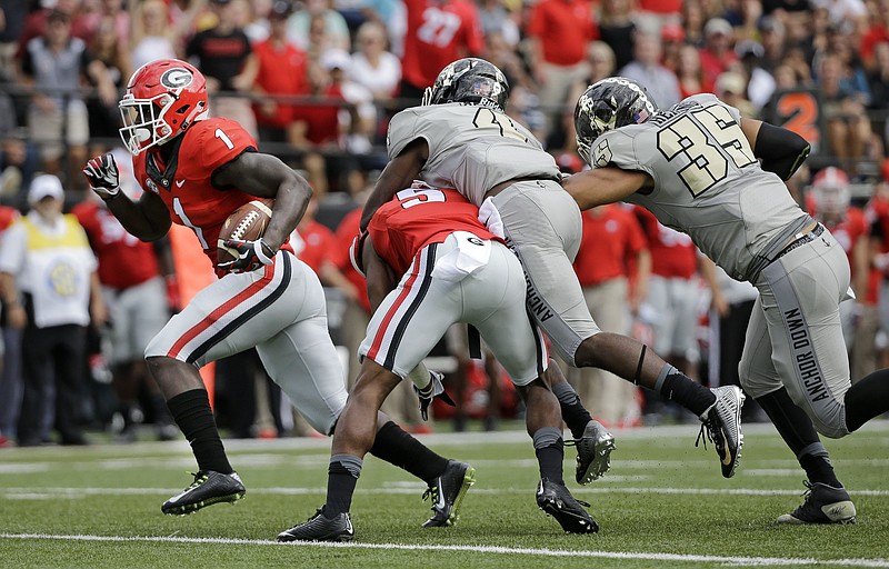 Georgia running back Sony Michel (1) gets past Vanderbilt defenders Tre Bell (4) and Darreon Herring (35) as Michel runs 31 yards for a touchdown in the first half of an NCAA college football game Saturday, Sept. 12, 2015, in Nashville, Tenn. 