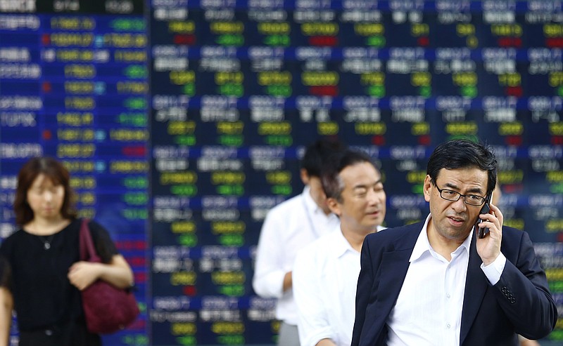 
              A man talks on a mobile phone in front of an electronic stock indicator of a securities firm in Tokyo, Monday, Sept. 14, 2015. Asian stocks were mostly lower Monday after China reported weak factory output and as investors looked ahead to a U.S. Federal Reserve decision this week on whether to raise interest rates. Japan's Nikkei 225 fell 1.6 percent to 17965.70. (AP Photo/Shizuo Kambayashi)
            