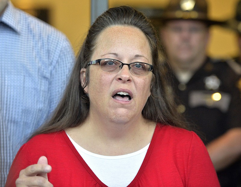 
              Rowan County Clerk Kim Davis makes a statement to the media at the front door of the Rowan County Judicial Center in Morehead, Ky., Monday, Sept. 14, 2015. Davis announced that her office will issue marriage licenses under order of a federal judge, but they will not have her name or office listed. (AP Photo/Timothy D. Easley)
            