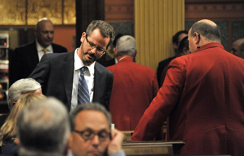 
              FILE - In this Sept. 11, 2015 file photo, House sergeants escort state Rep. Todd Courser, standing left, from the chamber after he signed a letter of resignation in Lansing, Mich. The extramarital affair between Courser and Rep. Cindy Gamrat became public last month, ultimately leading to both Republicans losing their seats. (Dale G. Young/Detroit News via AP, File)  DETROIT FREE PRESS OUT; HUFFINGTON POST OUT; MANDATORY CREDIT
            