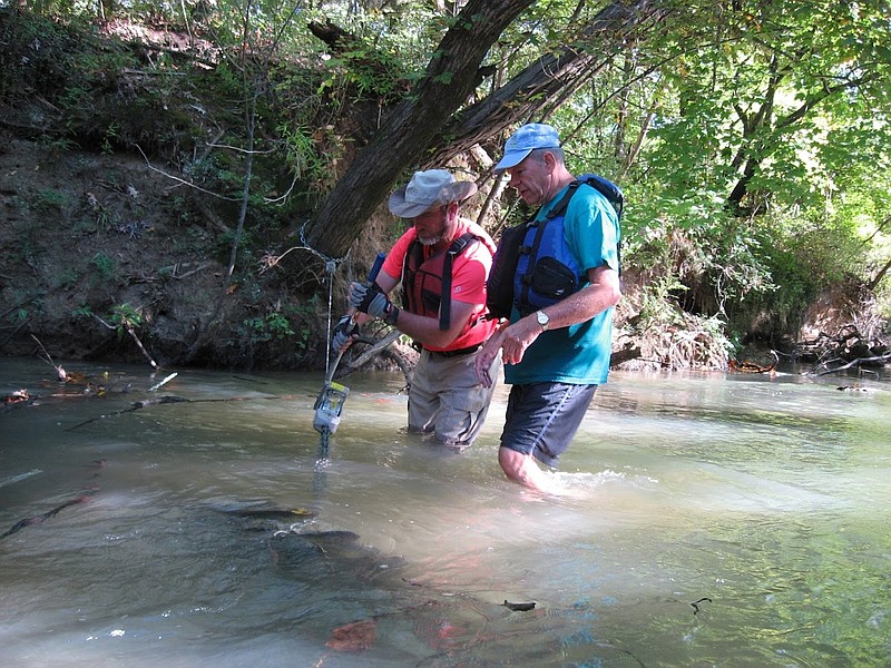 Tennessee Valley Canoe Club members Ben Johnson, left, and Eric Fleming use a chain hoist to remove a submerged tractor tire from West Chickamauga Creek in the Camp Jordan area during last year's Tennessee River Rescue.