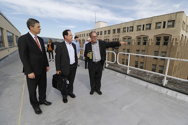 Chattanooga Mayor Andy Berke, Bookings Vice President Bruce Katz and The Enterprise Center's President & CEO Ken Hays, from left, converse on the rooftop during a tour of the Edney Building which will soon become the new hub of the Innovation District housing CoLab and the Enterprise Center.