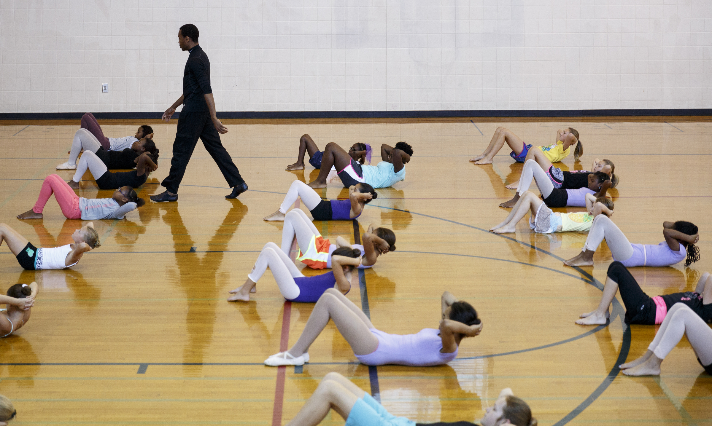 Dancer Fred Davis walks among students doing sit-ups during warmups in a master class in dance at the Brainerd Recreation Center on Tuesday, Sept. 15, 2015, in Chattanooga, Tenn. Davis, a Chattanooga native and Center for Creative Arts graduate, is now a professional dancer working in New York City.