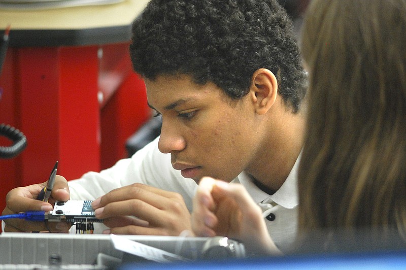 Tyner student Frederick Stone (left) and Derek Thomas work on building circuits at the digital analog trainer.