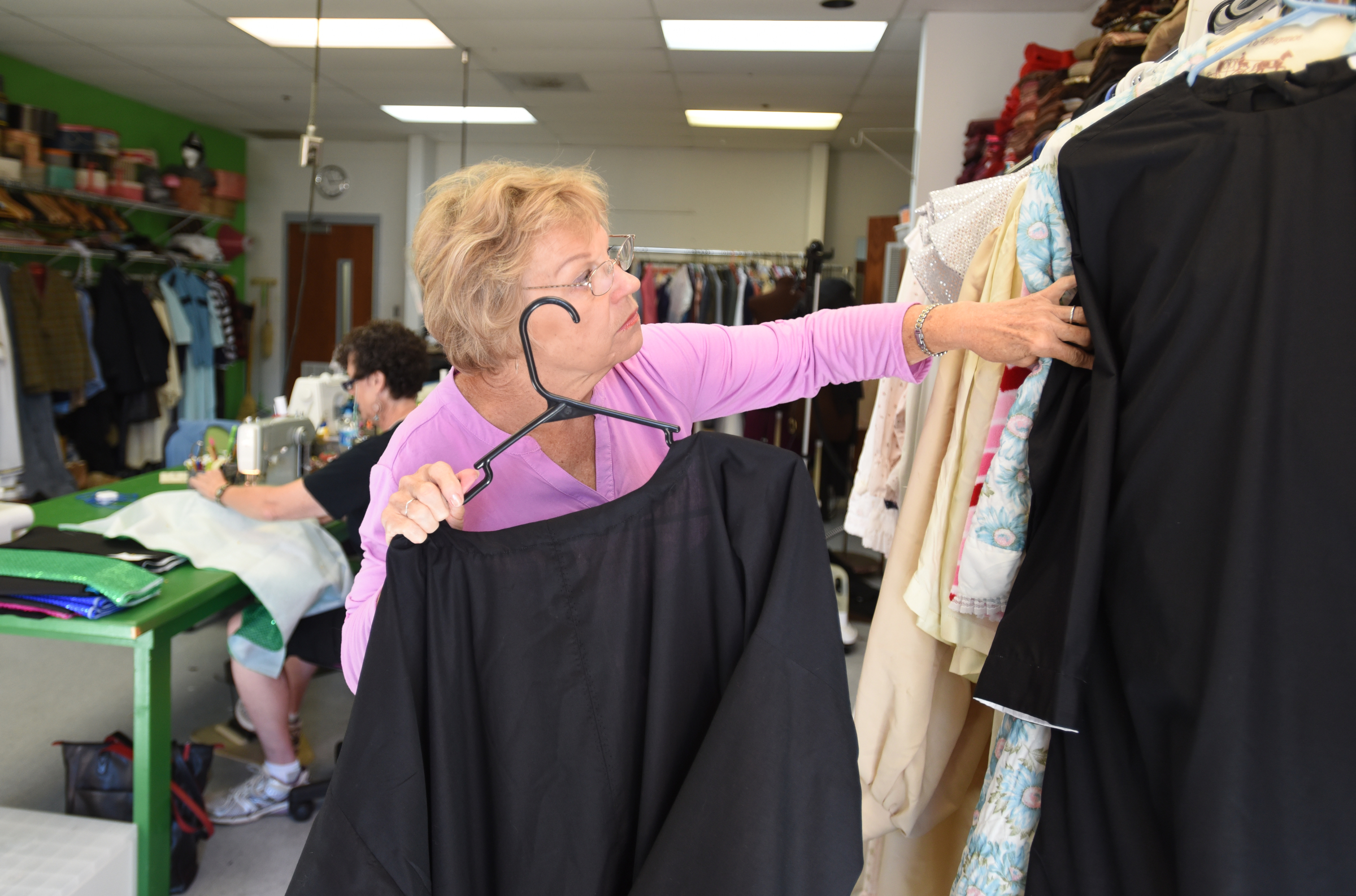 Kitty Murakami hangs costumes in the backroom work area at the Chattanooga Theatre Centre.