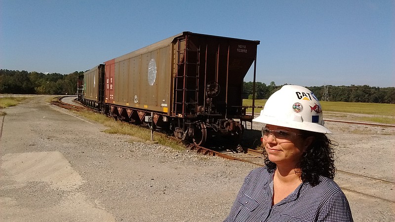 Marsha Humphres, coal yard supervisor at 
Widows Creek Fossil Plant, stands near the final 
two coal cars to deliver fuel to the plant, which 
closes later this month.