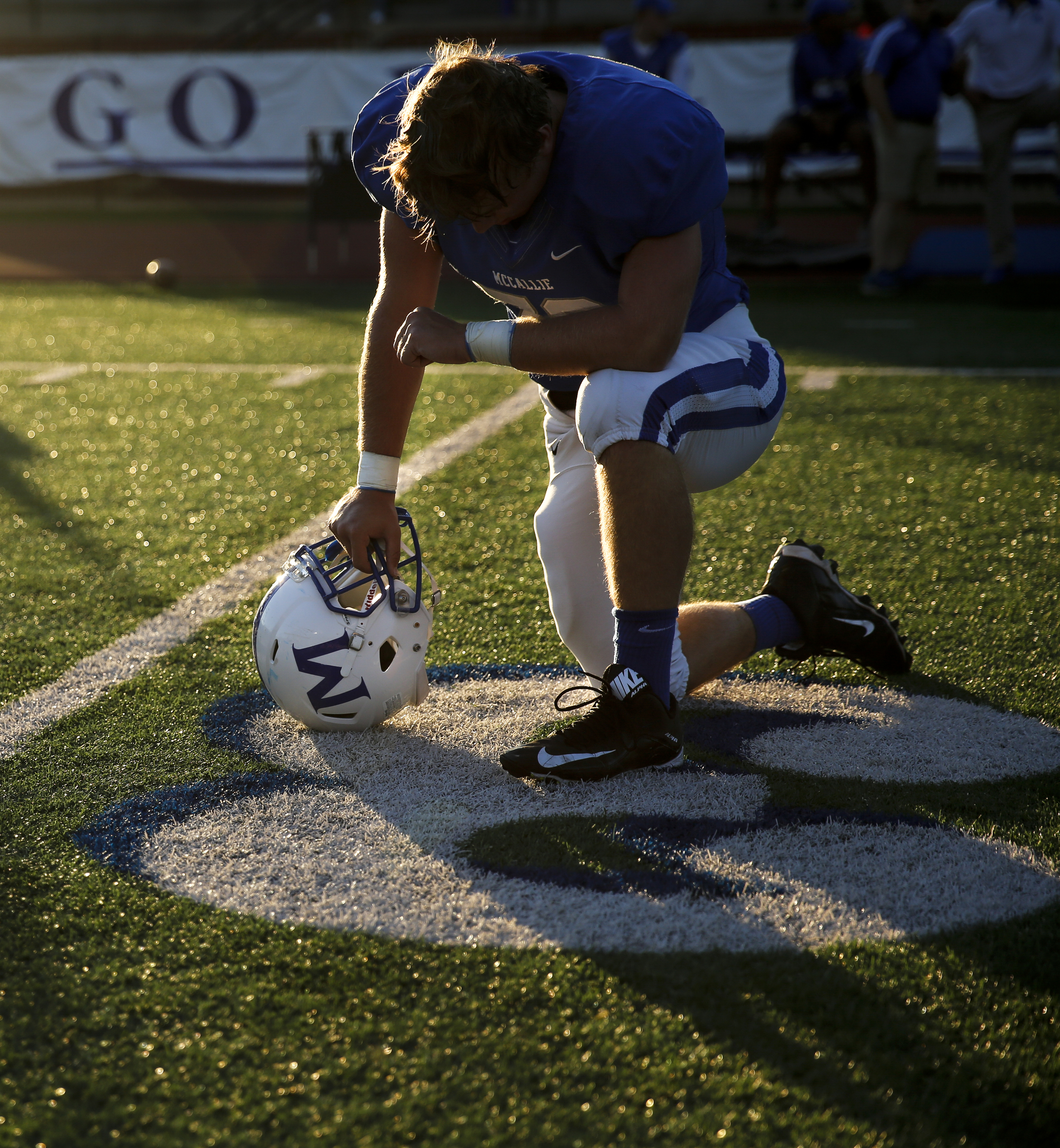 McCallie player Jack Green takes a knee before leaving the field after warmups for the tornados' prep football game against Montgomery Bell Academy at McCallie School on Friday, Sept. 18, 2015, in Chattanooga, Tenn.