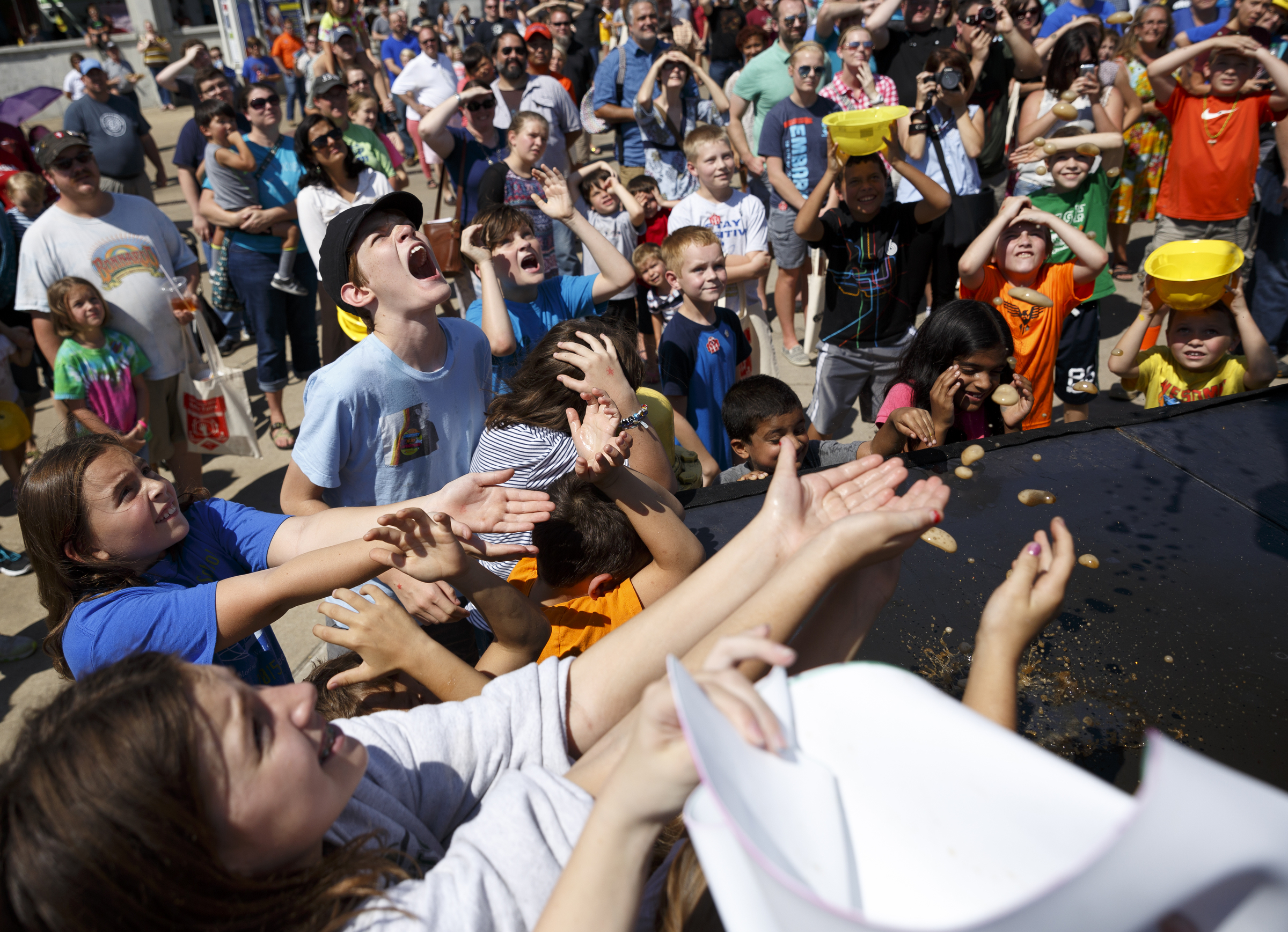 Children wait for diet soda to rain from the sky during a presentation by YouTube video creators EepyBird, known for their Diet Coke and Mentos experiment videos, during the Chattanooga Mini Maker Faire at the First Tennessee Pavilion on Saturday, Sept. 19, 2015, in Chattanooga, Tenn. The faire is a celebration of creators and their creations, and it showcased makers ranging from technology enthusiasts to crafts artisans.
