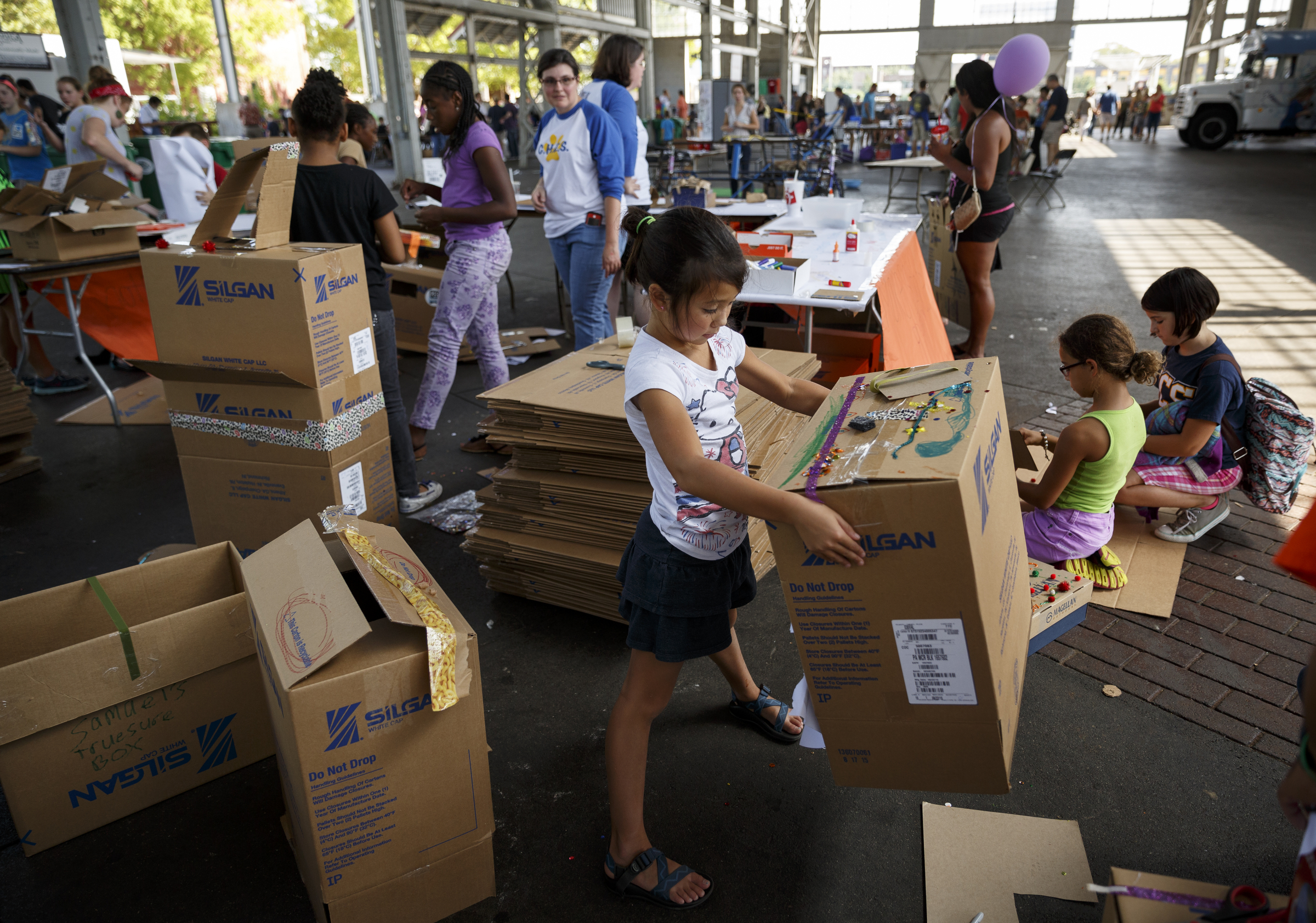 Lydia Mizutani holds up a cardboard box she decorated for the Global Cardboard Challenge during the Chattanooga Mini Maker Faire at the First Tennessee Pavilion on Saturday, Sept. 19, 2015, in Chattanooga, Tenn. The faire is a celebration of creators and their creations, and it showcased makers ranging from technology enthusiasts to crafts artisans.