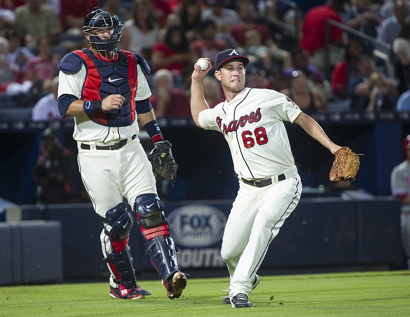 Atlanta Braves pitcher Ryan Weber (68) throws out Philadelphia Phillies' Brian Bogusevic at first base as catcher A.J. Pierzynski backs him up during the seventh inning of a baseball game,Saturday, Sept. 19, 2015, in Atlanta. 
