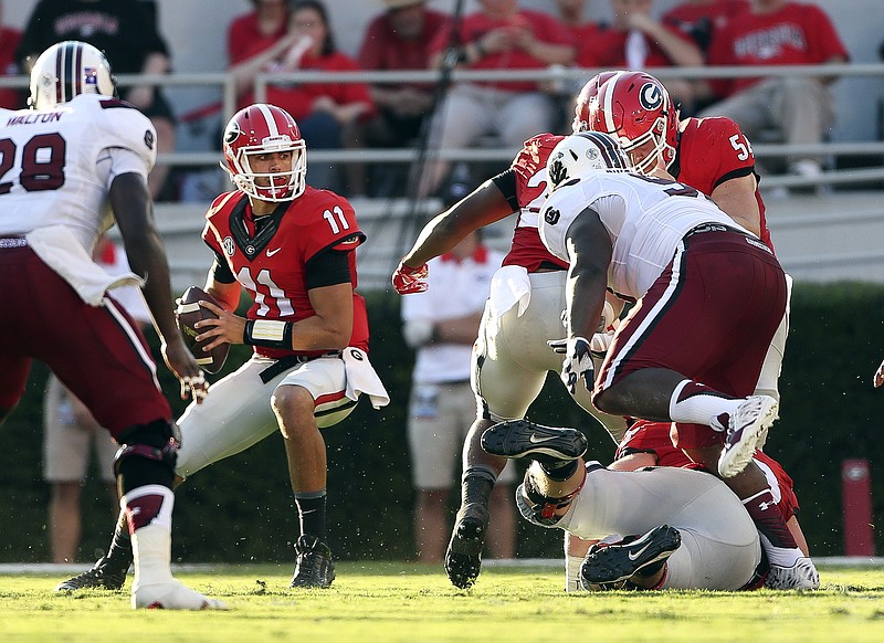 Georgia quarterback Greyson Lambert (11) looks for an open receiver under pressure from the South Carolina defense during his game Saturday, Sept. 19, 2015, in Athens., Ga. Georgia won 52-20.