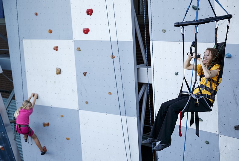 Charity Trillet, right, uses a Wellman System harness to ascend a wall without using her legs during as Harley Curd climbs nearby during an adaptive climbing program at High Point Climbing gym Thursday, Sept. 17, 2015, in Chattanooga, Tenn. The program, which happens on the third Thursday of each month, provides resources to help disabled climbers enjoy the sport.