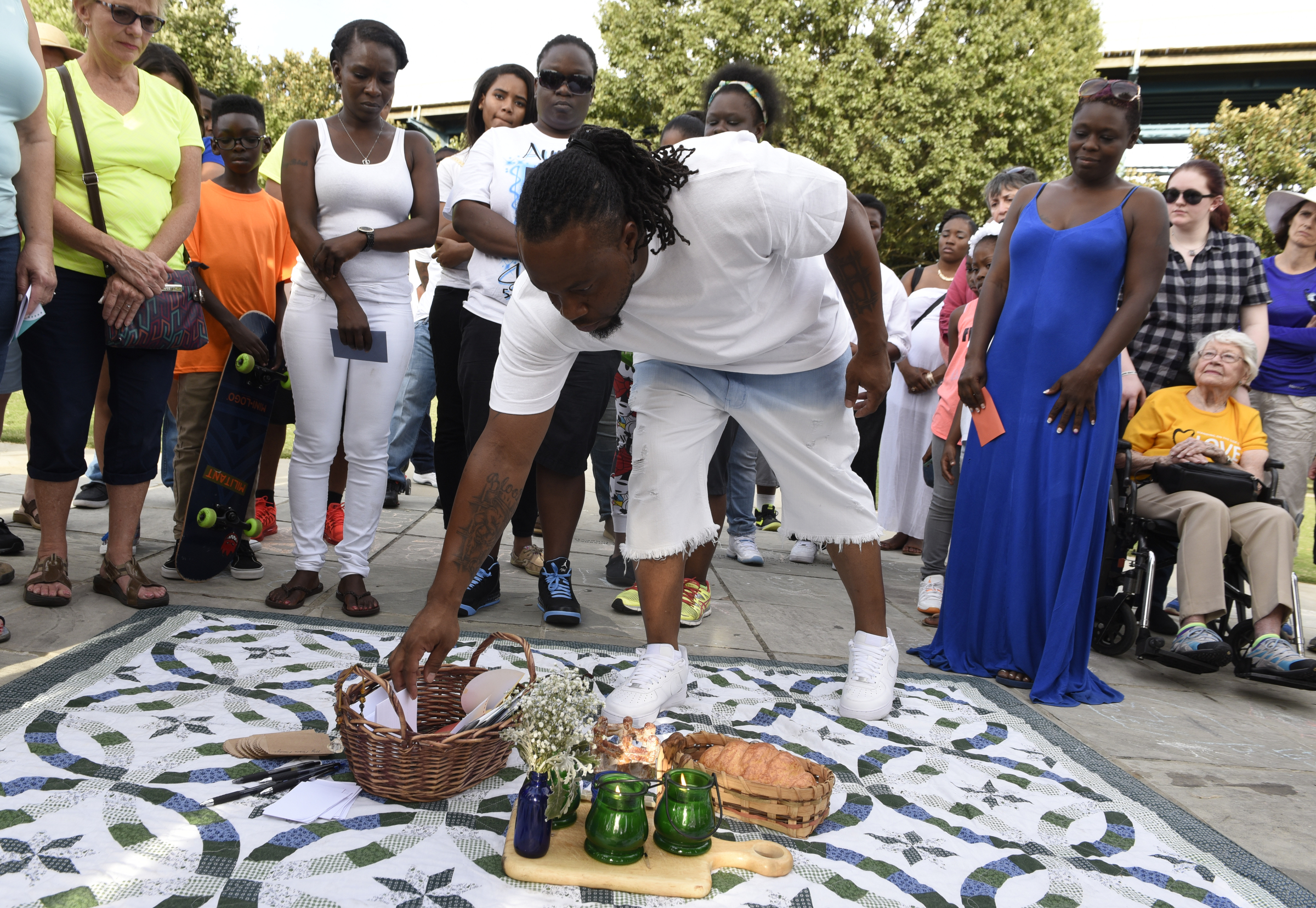 Bobby Paris drops a card into a basket with the name of his son, Jordan Clark, during a prayer walk on Sunday, Sept. 20, 2015, in Chattanooga, Tenn., in remembrance of families affected by violence. Jordan Clark was killed in a Willow Street shooting on Aug. 25.