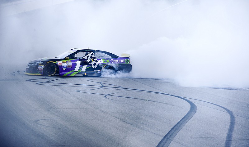 Denny Hamlin does a burnout after winning the NASCAR Sprint Cup Series auto race at Chicagoland Speedway, Sunday, Sept. 20, 2015, in Joliet, Ill.