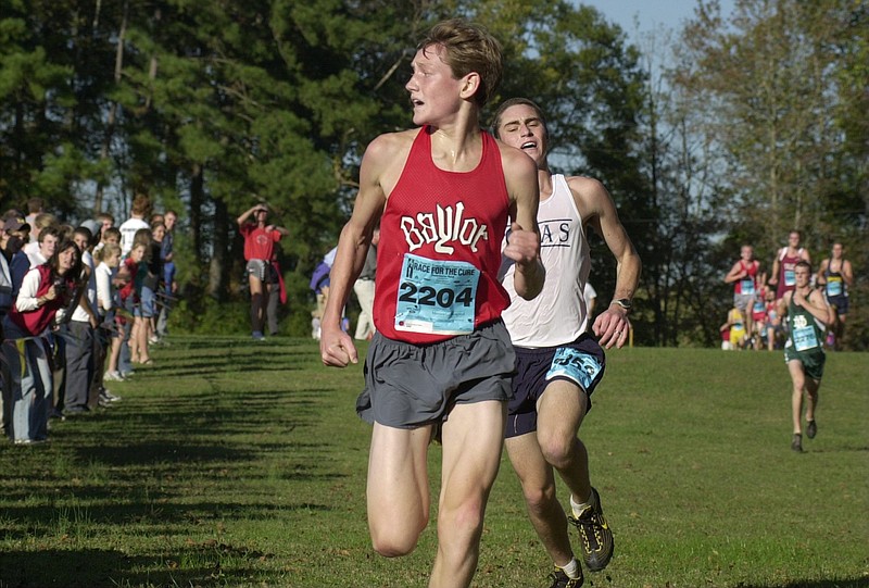 In this 2003 file photo, Cameron Bean looks back to see CSAS's Jordan Longstreth close behind in the finish shoot at the Optimist City Cross Country Championship. Both Baylor boys and girls varsity took first place in the competition.