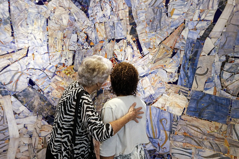 Inelda Hefferlin, left, chats with Lillie Wills about the mosaic wall of Erlanger hospital's new interfaith chapel.